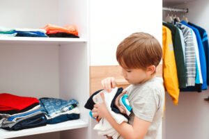 kid organizing closet and clothes